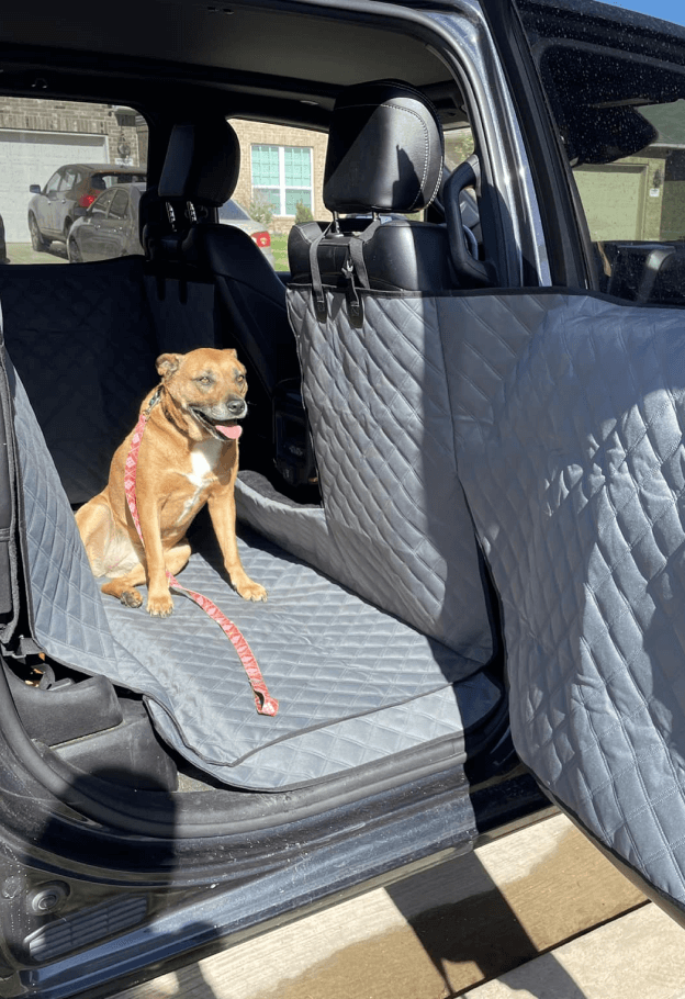 Customer's dog sitting on a gray Ruff Liners cover with the door panel covered